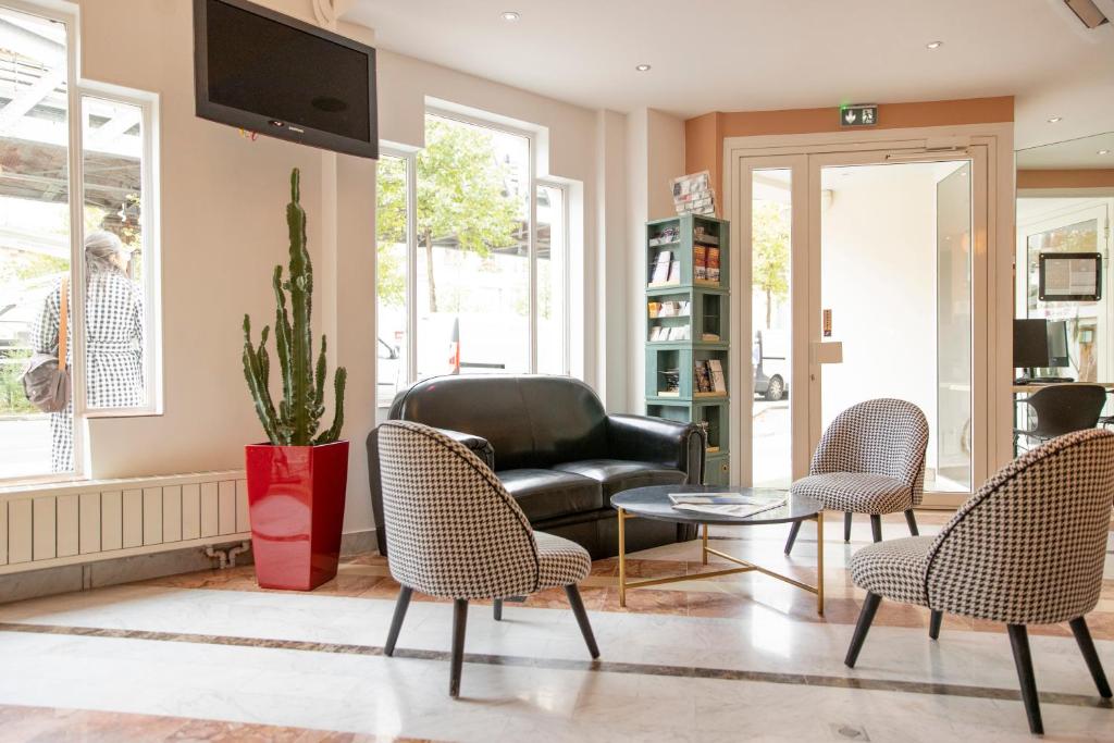 巴黎Hôtel Baldi by Magna Arbor的客厅配有沙发、椅子和桌子