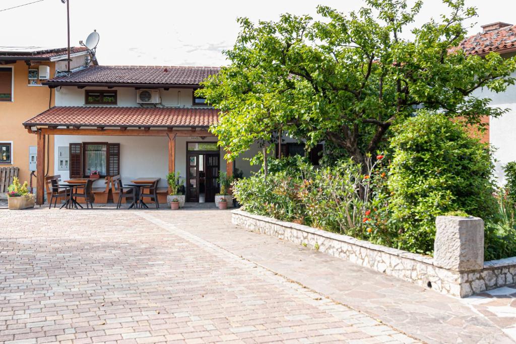 SlapPenzion Na Hribu的砖砌车道和庭院的房子