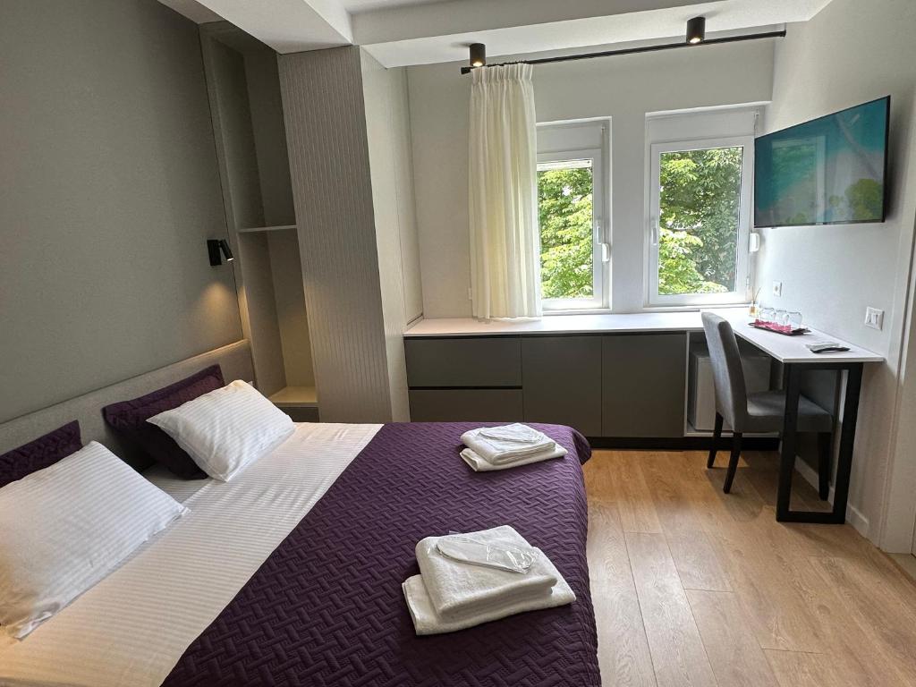 地拉那Soin Rooms的一间卧室配有一张床、一张书桌和一个窗户。