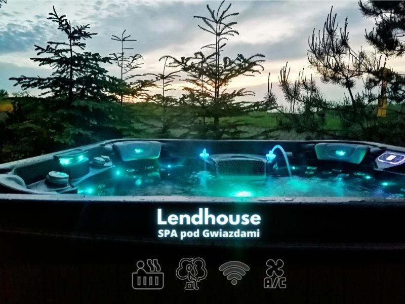 SąpówLendHouse - SPA pod Gwiazdami的庭院内带蓝色灯光的按摩浴缸
