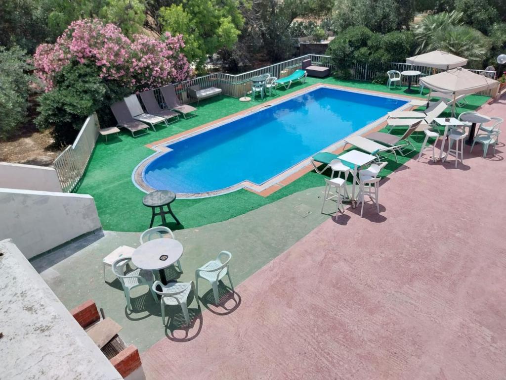 SalinaWhitestar Guesthouse的享有带桌椅的游泳池的顶部景致