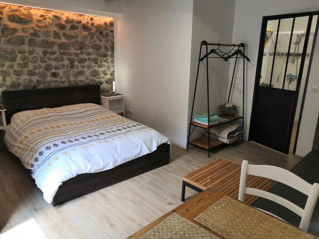 Saint-Dalmas-le-Selvage小星星住宿加早餐旅馆的一间卧室设有一张床和砖墙