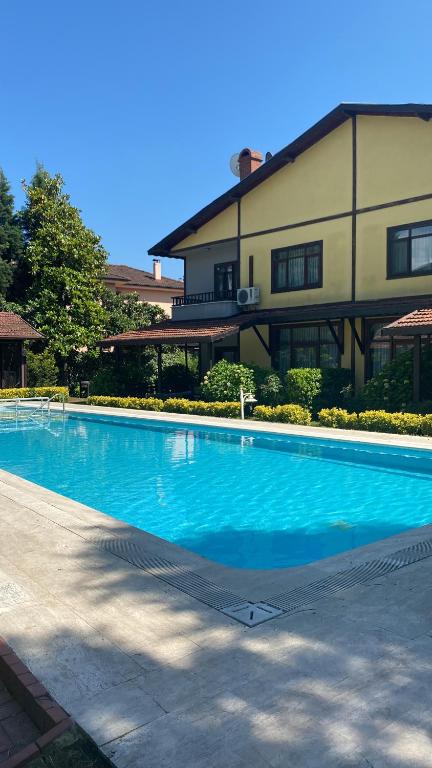 萨潘贾Four seanson müstakil sıcak havuzlu villa的大楼前的大型蓝色游泳池