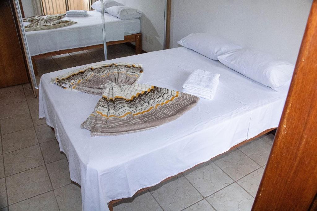贝洛奥里藏特Casa de 2 Suítes com Internet Rápida e Comodidades的一张白色的床,上面有一条毯子