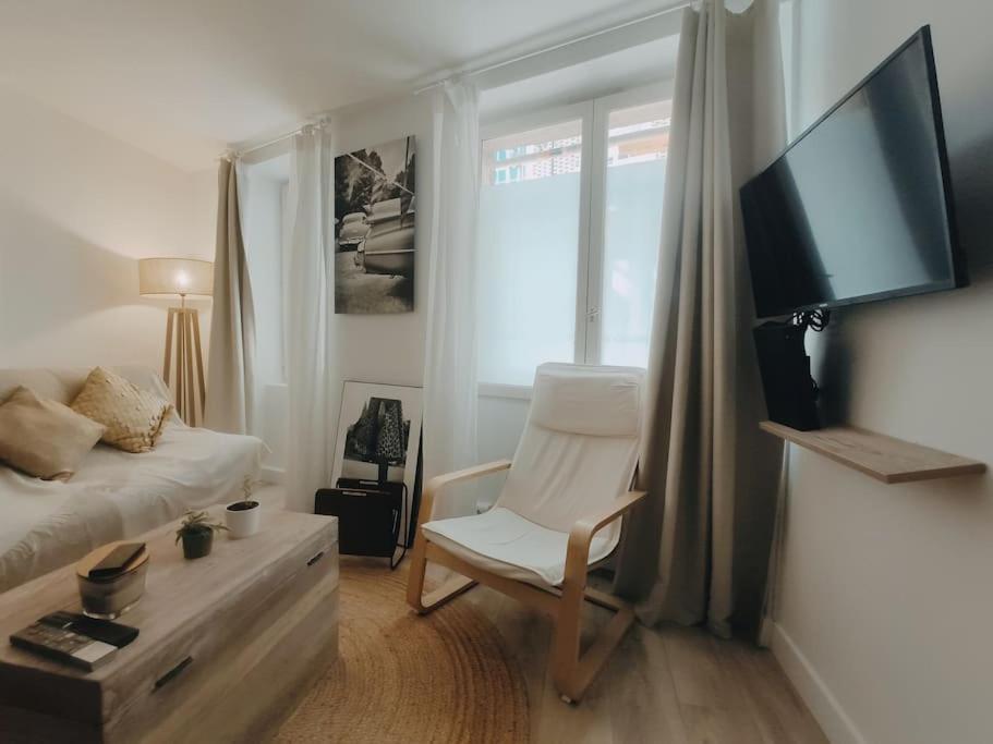 沙朗通勒蓬Cosy Appartement 4P proche 12eme/Vincennes的一间卧室配有一张床、一把椅子和电视。