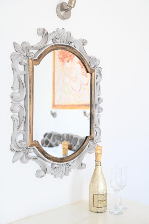 卡马利Villa Maina的一张桌子上的镜子和一瓶葡萄酒