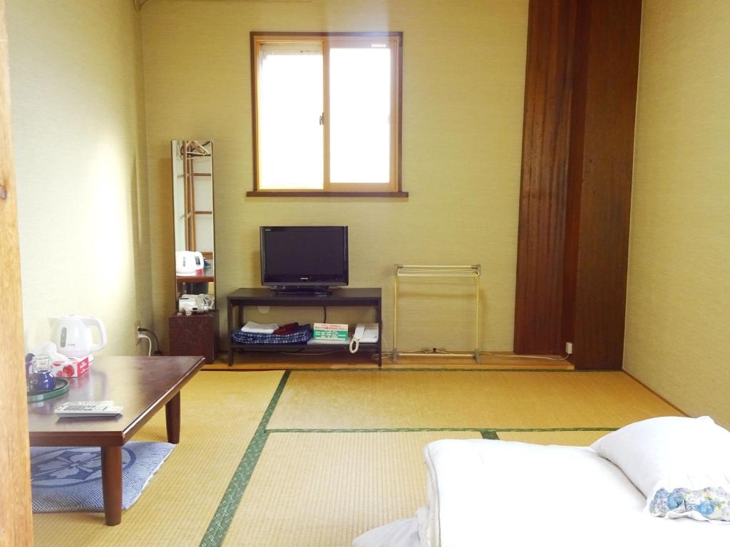 大阪Imazato Ryokan - Vacation STAY 51063v的客厅配有电视和桌子