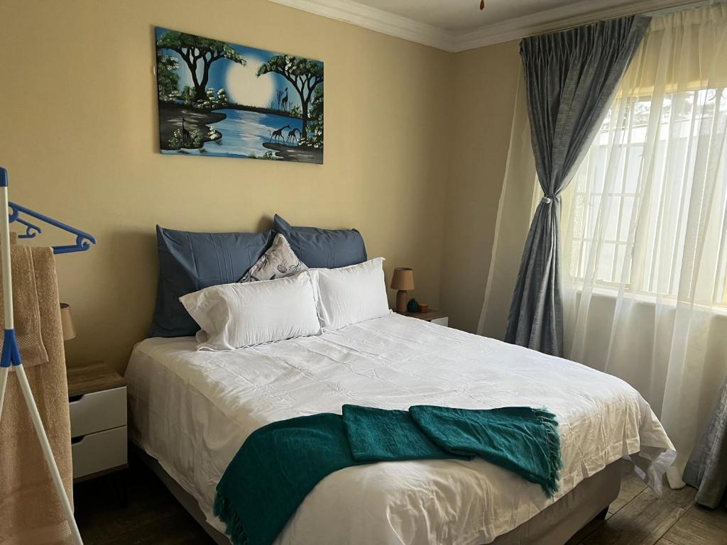 克鲁格斯多普Phindulo Bed and Breakfast - No Loadshedding, Smart TVs & unlimited free fibre wifi的一间卧室配有一张带绿毯的床