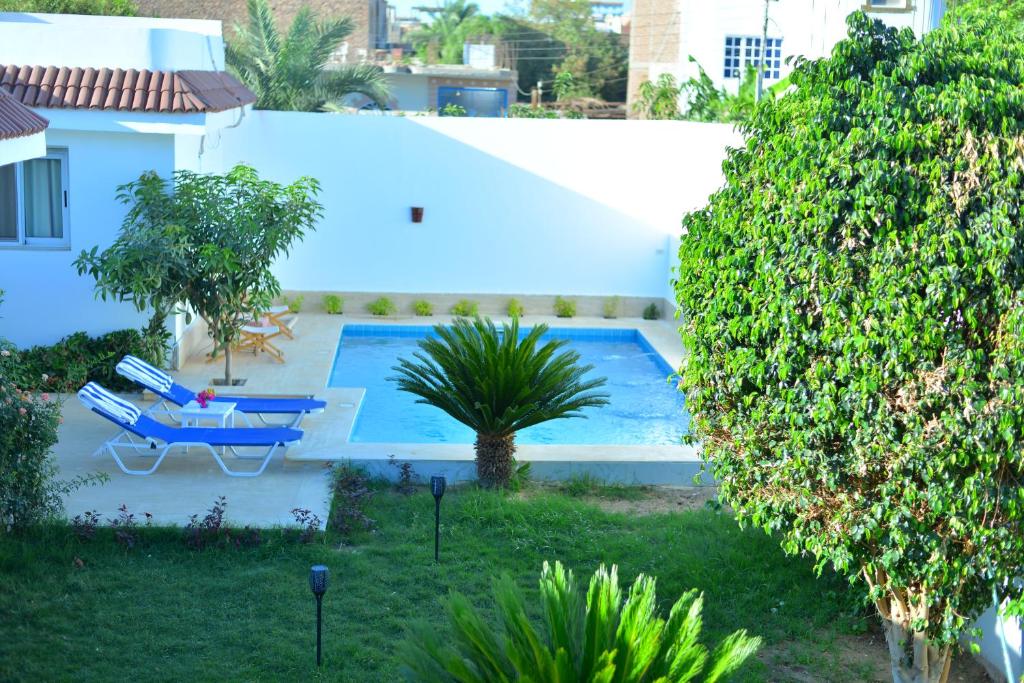卢克索Luxor Rose Villa的院内的一个游泳池,旁边设有一张蓝色的桌子