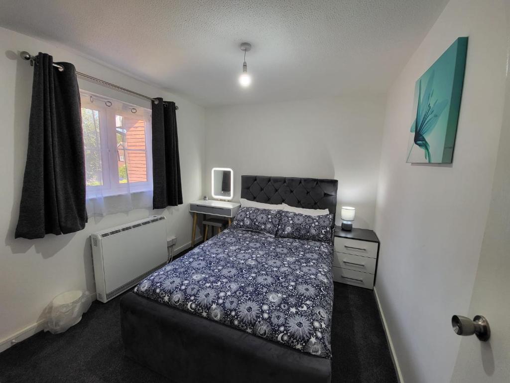 伦敦Delight Apartment, Close to Excel, London City Airport & O2!的一间卧室配有一张床、一张书桌和一个窗户。