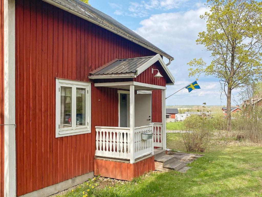 博伦厄Holiday home Borlänge II的红色的房子,有白色门廊和旗帜