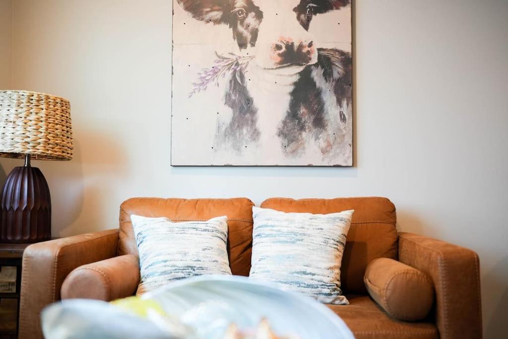 奥马哈1 Bedroom Stylish Oasis的客厅里一张棕色的沙发,墙上挂着一幅画