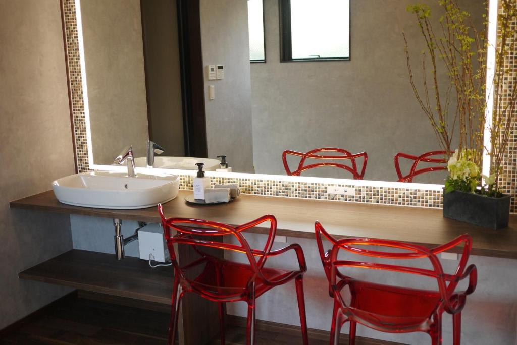 高冈市Marna family - Vacation STAY 69396v的浴室设有红色椅子、水槽和镜子