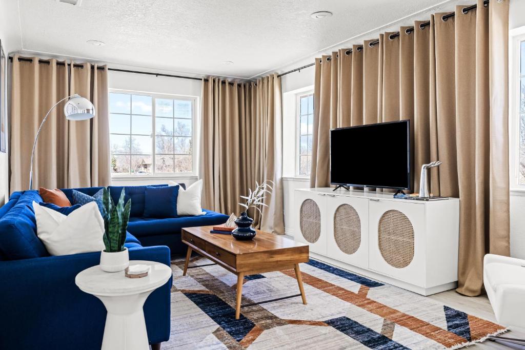 丹佛Bright & Modern Retreat - King Beds - Sloans Lake的客厅配有蓝色的沙发和电视