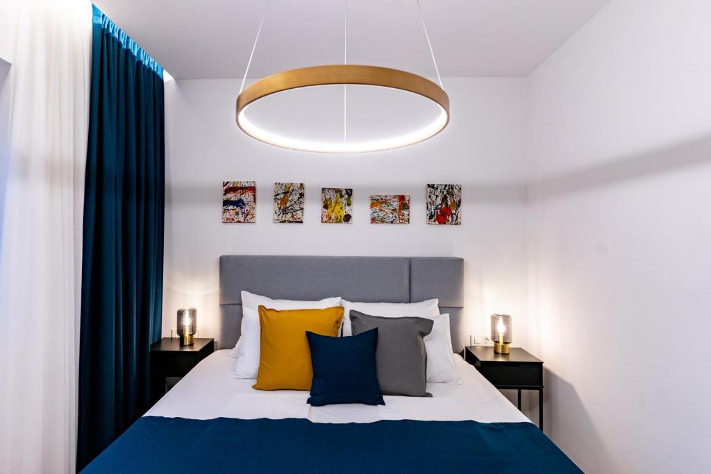 PalitPanorama Suite Dora with Jacuzzi的一间卧室配有黄色和蓝色枕头的床