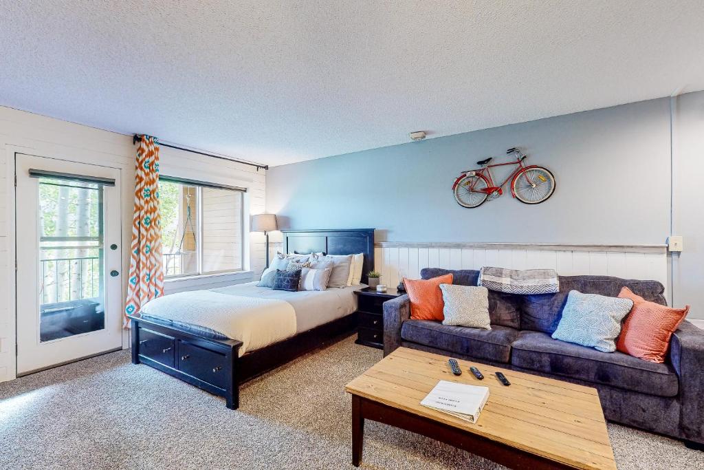 格兰比Overlook Nook #241的卧室配有一张床和一张沙发,墙上有一辆自行车