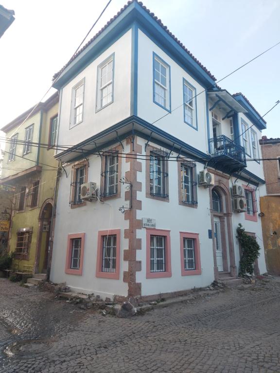 艾瓦勒克Mimosa House Ayvalık的白色的建筑,一边有十字架
