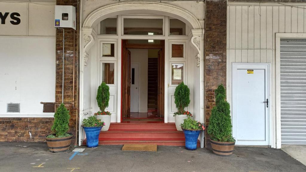斯特拉特福德Royal Accommodation的一座种植盆栽植物的建筑的前门