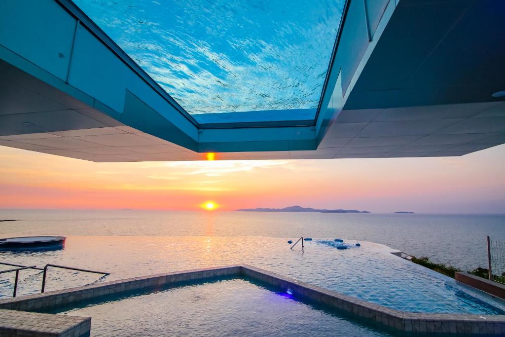 南芭堤雅Royal Cliff Beach Hotel Pattaya的享有日落的游泳池