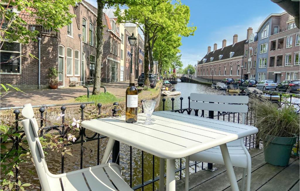 阿尔克马尔Beautiful Home In Alkmaar With Kitchen的一张带一瓶葡萄酒和两把椅子的白色桌子