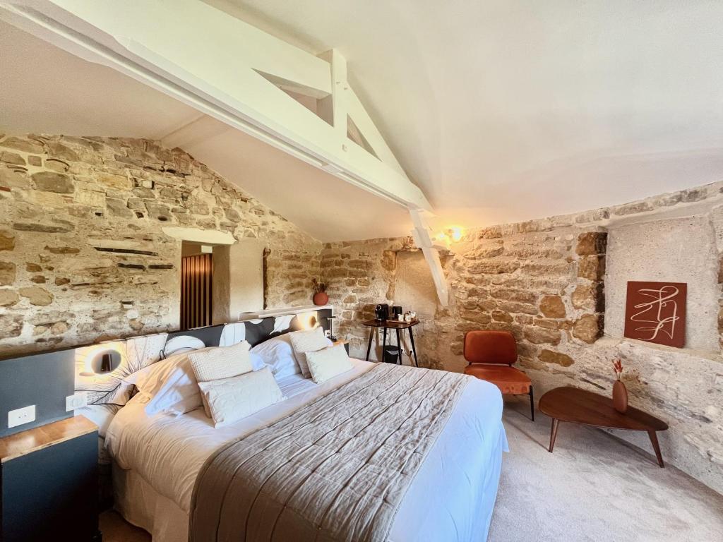 巴约讷贝司比利牛斯巴约讷酒店的卧室配有一张石墙内的大床