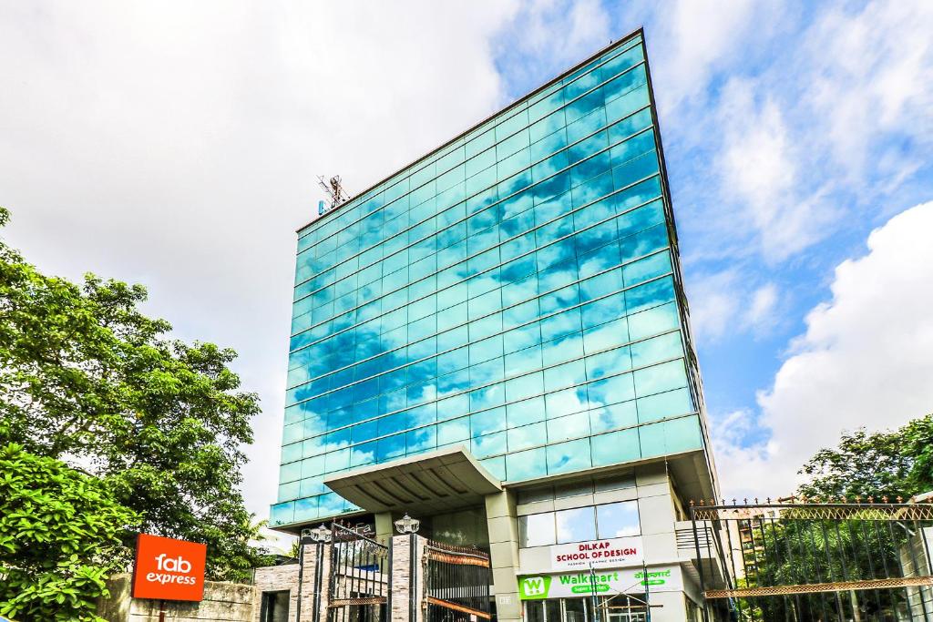 孟买FabExpress Ascot International Andheri East的一座高大的玻璃建筑,上面有一个人