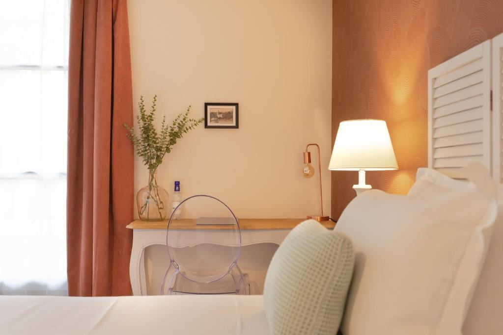 圣西普里安Hotel-Restaurant des Augustins - Cosy Places by CC - Proche Sarlat的一间卧室配有一张床和一张桌子及椅子