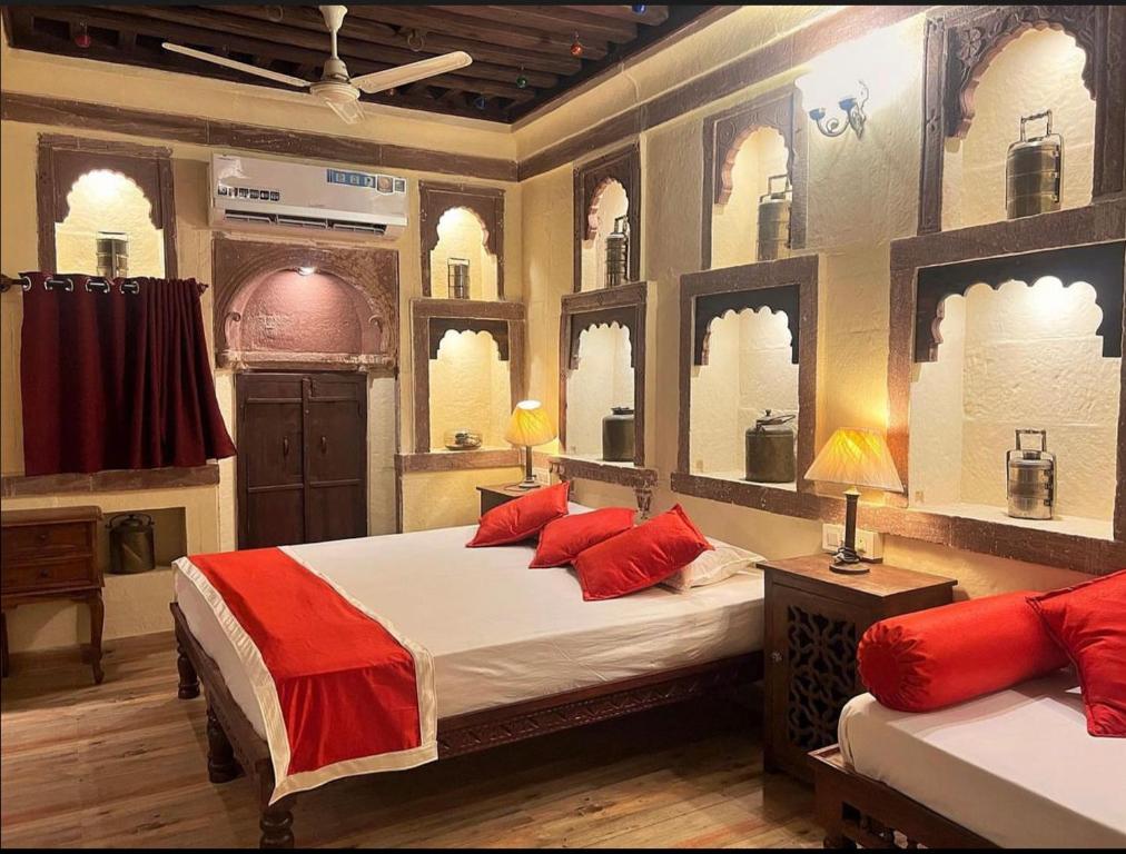 焦特布尔朱娜玛哈精品家庭住宿酒店的一间卧室配有两张带红色枕头的床和窗户。
