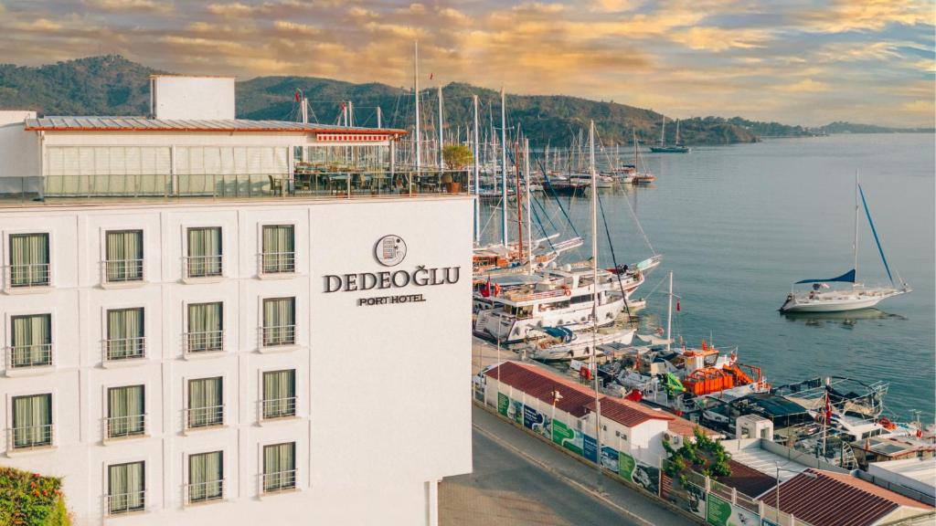 费特希耶Dedeoğlu Port Hotel的码头旁的一座楼,在水中划船