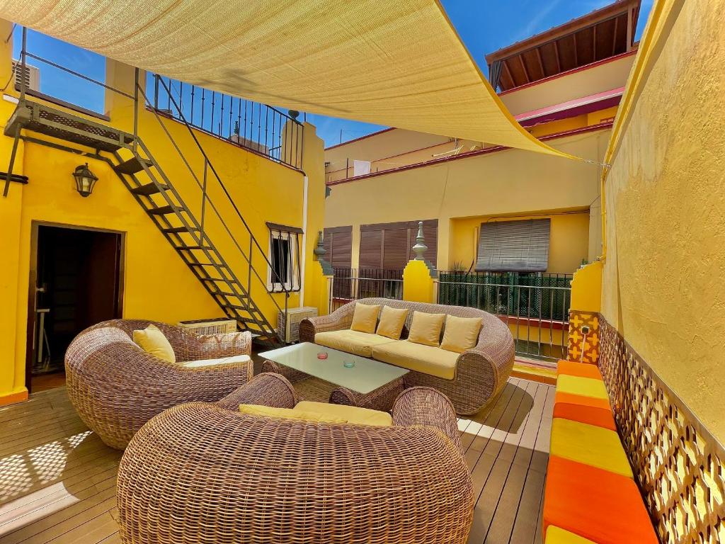 塞维利亚House -Rooftop&Jacuzzi -StayInSeville的庭院设有藤椅、沙发和桌子