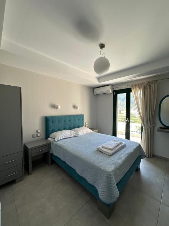 瓦西利基奥迪森酒店的一间卧室设有蓝色的床和窗户。