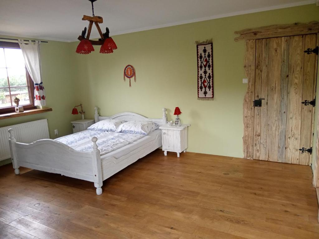 Chatka skrzatka的卧室配有白色的床,铺有木地板
