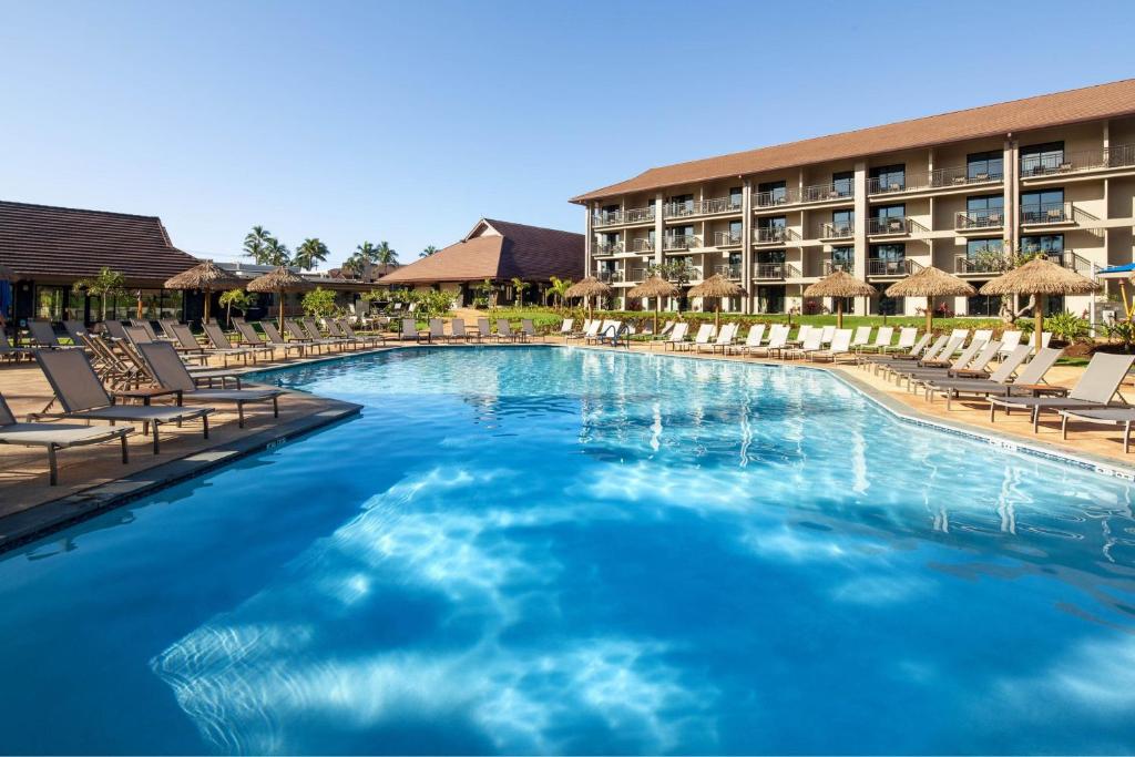 科洛阿Sheraton Kauai Resort Villas的一个带躺椅的大型游泳池和一间酒店