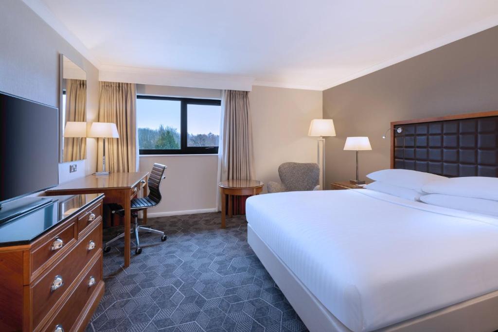 北安普敦Delta Hotels by Marriott Northampton的酒店客房配有一张床、一张书桌和一台电脑