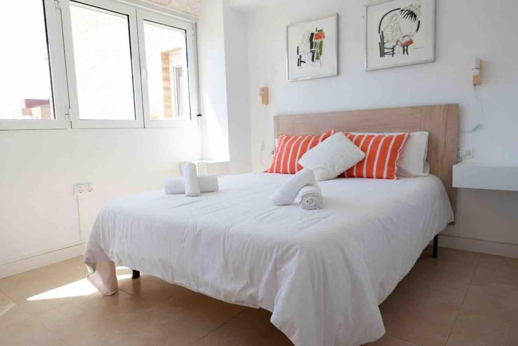 阿利坎特Gran apartamento, Aire acondicionado, piscina y parking gratuito的卧室配有一张白色大床和两个窗户