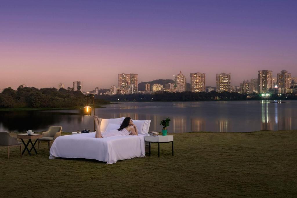 孟买孟买万丽会议中心酒店的躺在床上欣赏城市景色的女人