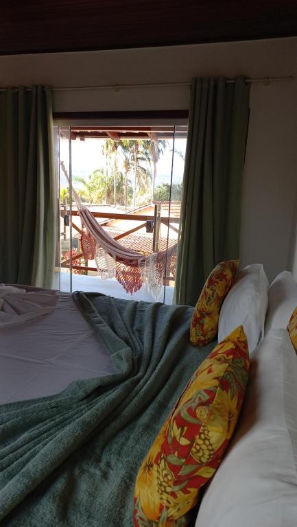 戈亚斯州上帕莱索POUSADA ACONCHEGO CHAPADA的一间卧室设有一张床,享有庭院的景色