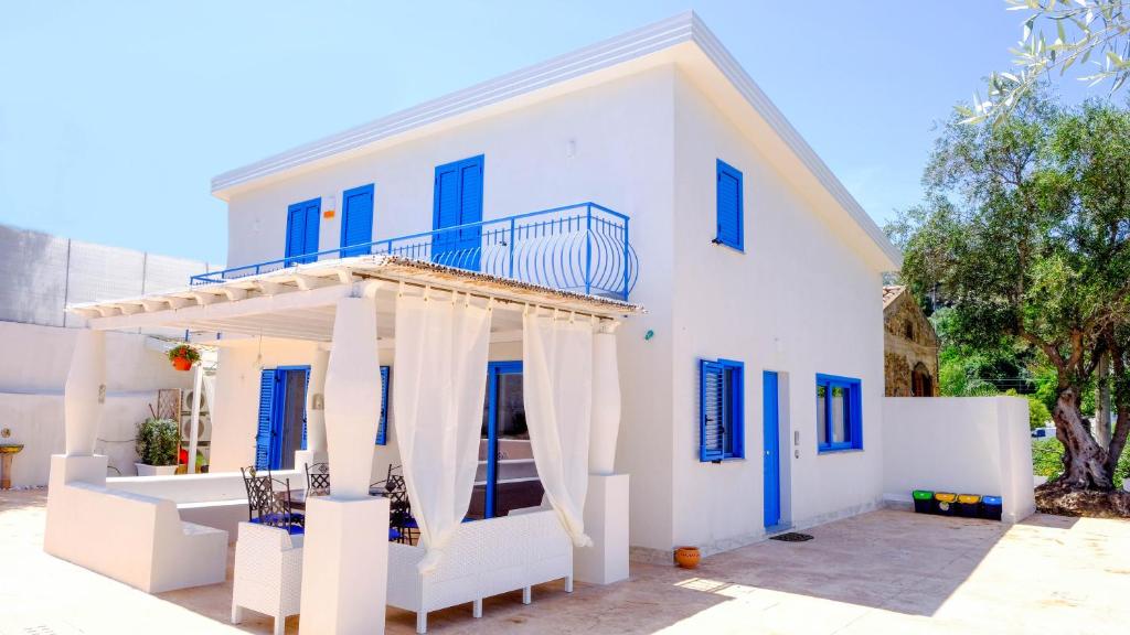 卡普多兰多Villa dei Due Ulivi的白色的房子设有蓝色的窗户和阳台