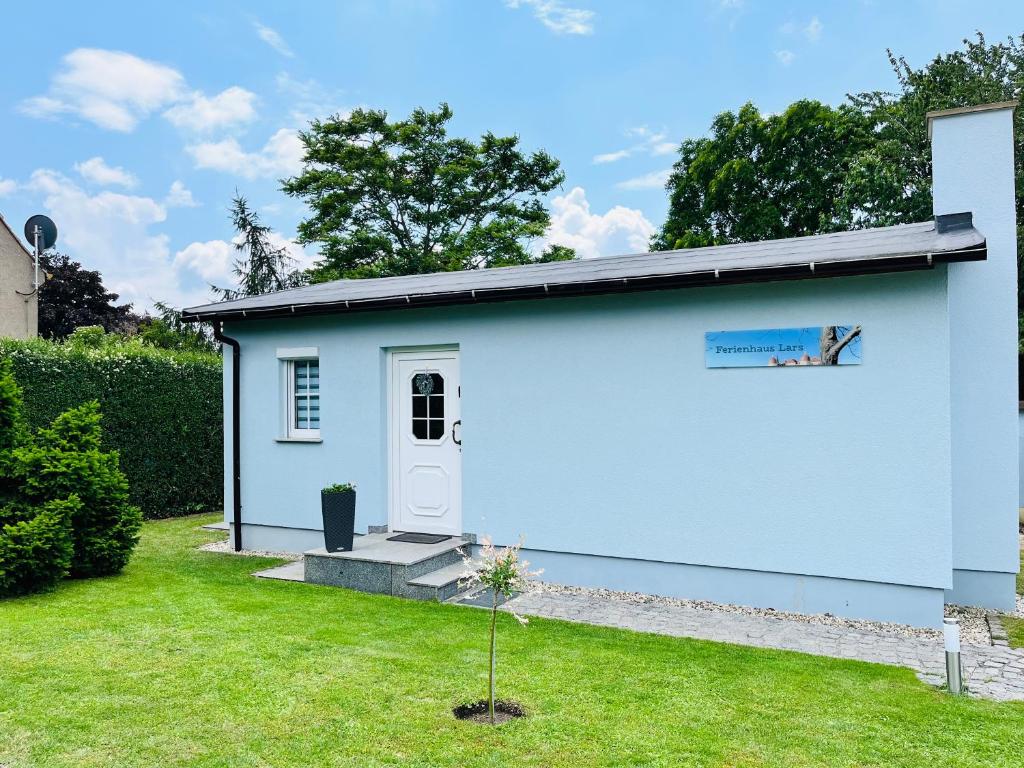 莫里茨堡Ferienhaus Lars的一座带草地庭院的蓝色小房子