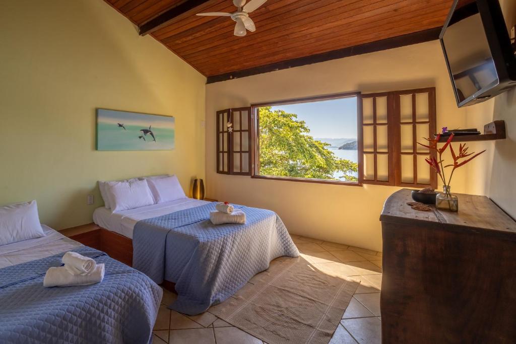 阿拉夏奇巴海滩Pousada Cruzoé的一间卧室设有两张床和大窗户