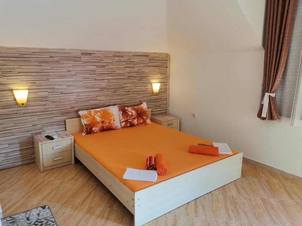 索佐波尔Виктория Созопол的一间卧室配有一张带橙色床单的大床