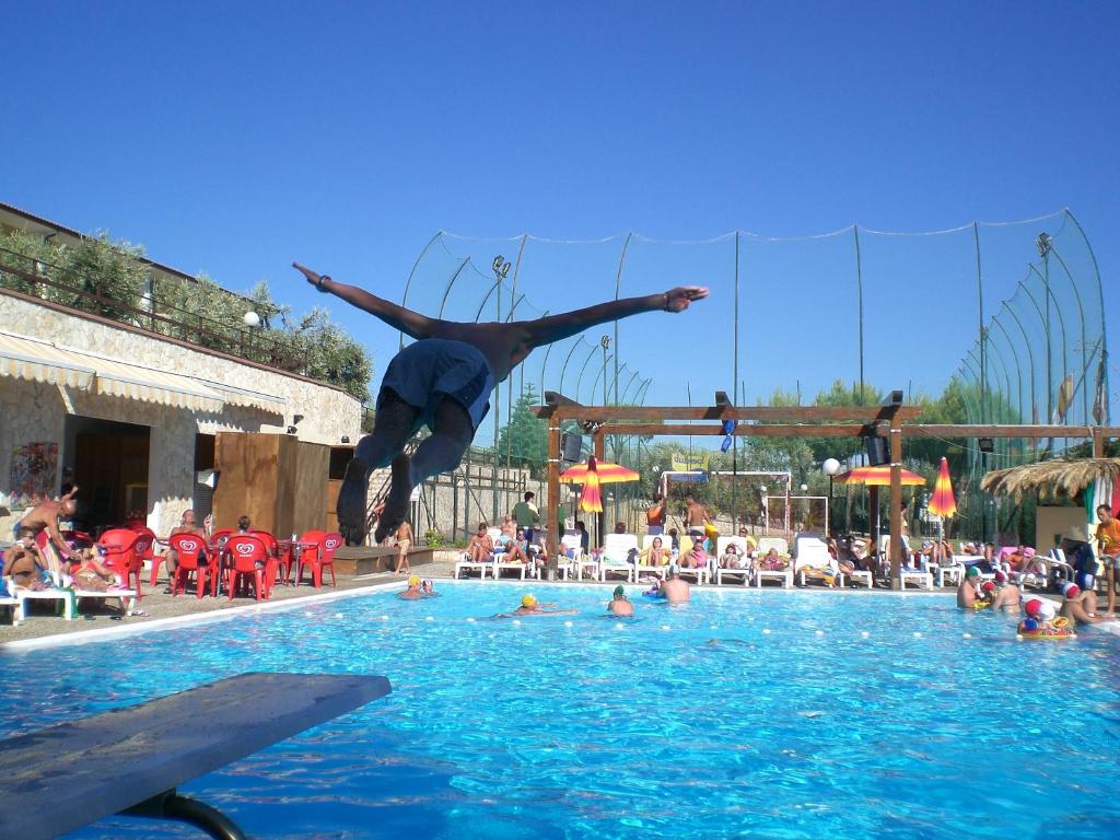 维耶斯泰Villaggio Turistico Defensola的一个人跳进游泳池