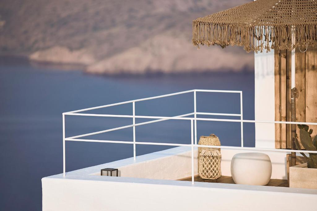普拉卡米洛斯Niove Suites Milos的上面有蓝色玻璃的白色桌子