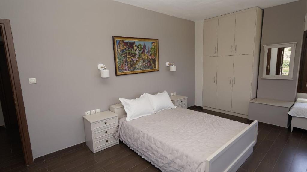 费索斯Villa Faihs的卧室配有白色的床和墙上的绘画作品