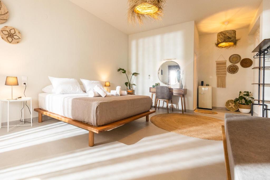 斯基亚索斯镇Dohos Skiathos Suites的一间卧室配有一张床、一张桌子和一面镜子