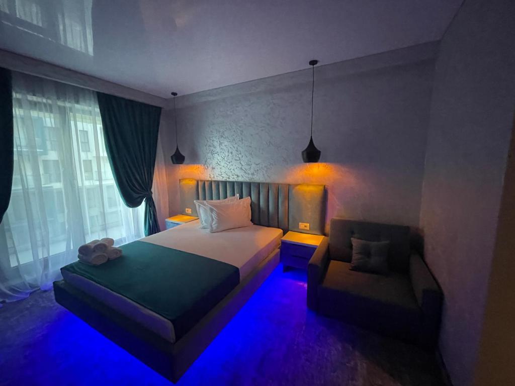 那沃达利HOTEL KALYA的一间卧室配有一张床和一把带蓝光的椅子