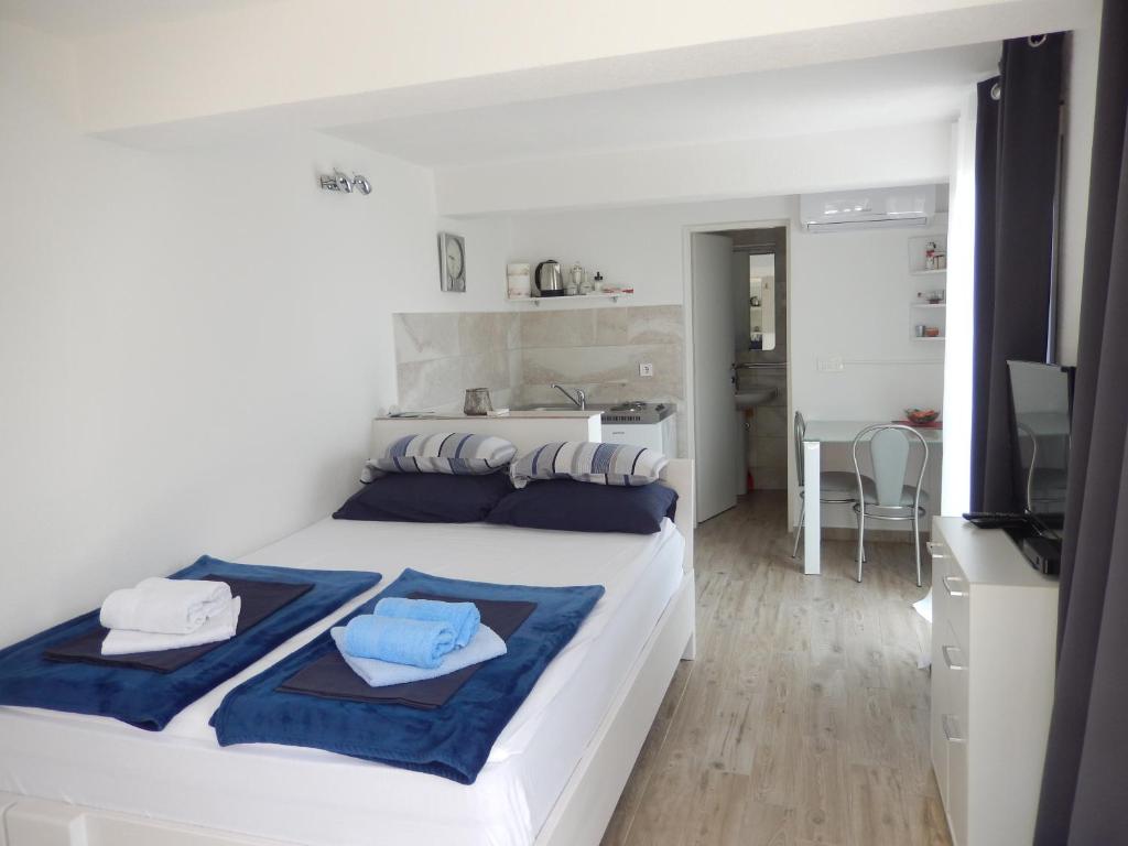 巴比诺波尔杰New studio app for 2的卧室配有带蓝色枕头的大型白色床