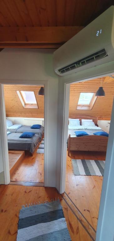 艾杰克Buborék Apartman - Etyek的带天窗的客房内设有几张床的房间