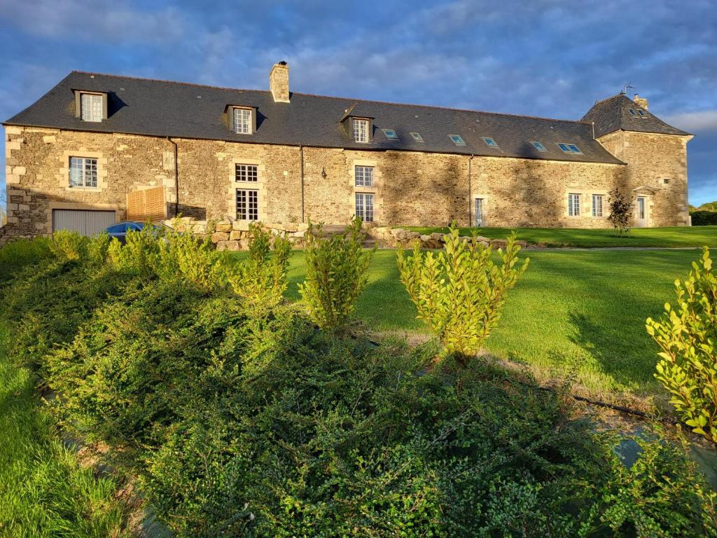 塔登Manoir de La Garaye - Suite Parentale的一座带绿色庭院的大型石屋
