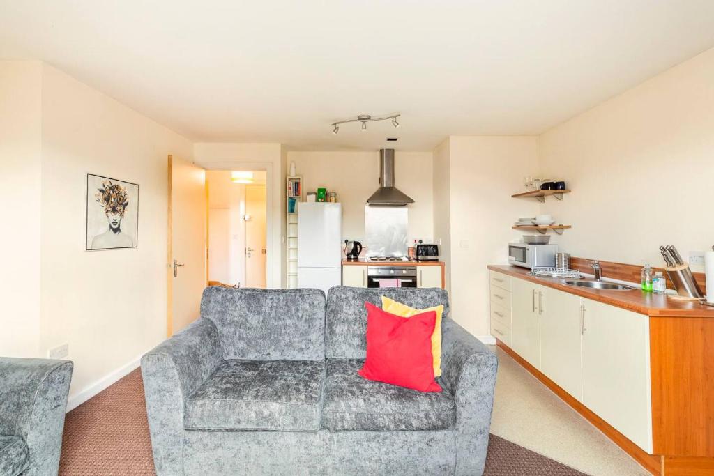曼彻斯特Mosh Aparthotel Salford的带沙发和红色枕头的客厅